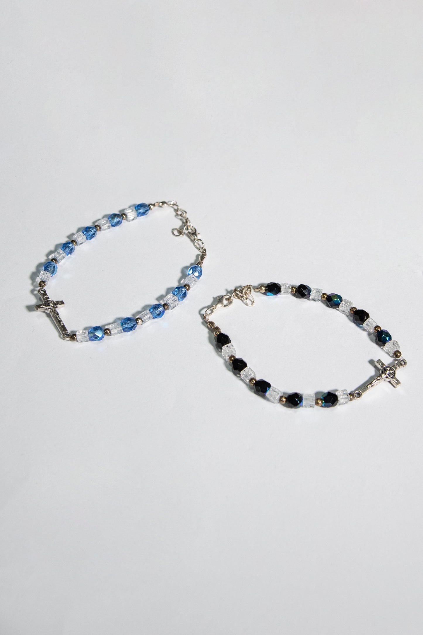 Bracciale mezzo crisatallo di colore azzurro e nero con crocetta San Benedetto - Magnificat