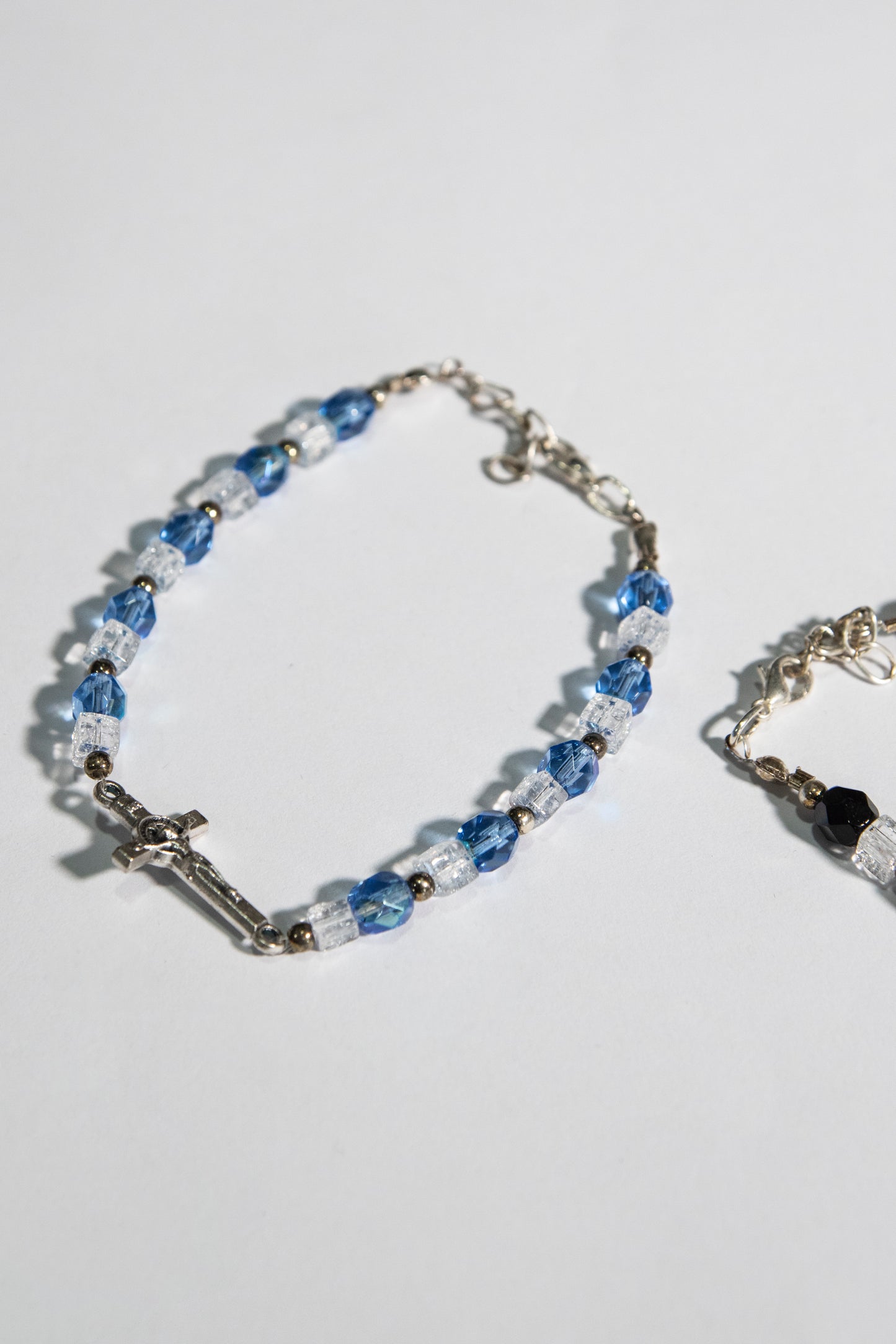 Bracciale mezzo crisatallo di colore azzurro e nero con crocetta San Benedetto - Magnificat