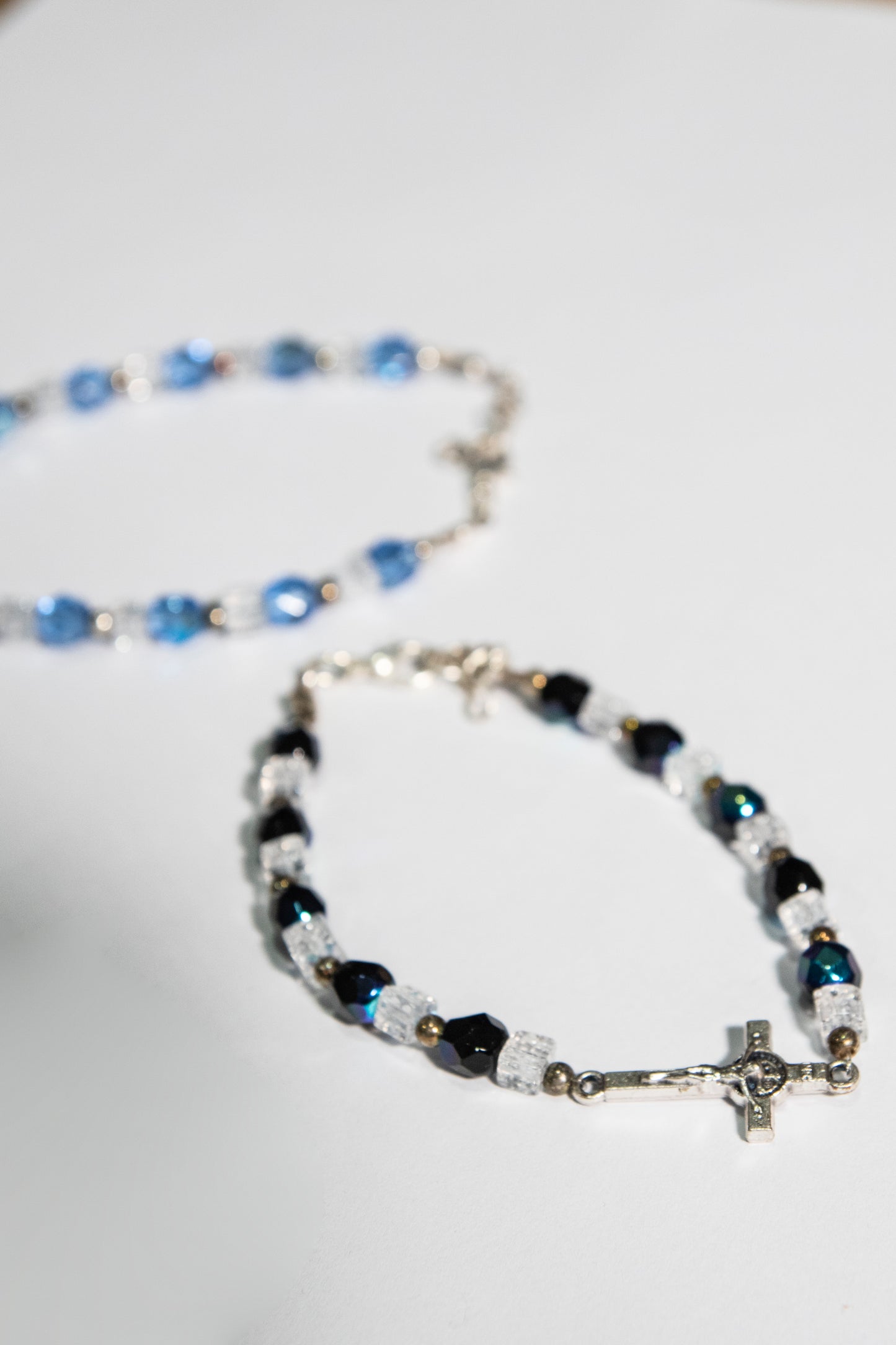 Bracciale mezzo crisatallo di colore azzurro e nero con crocetta San Benedetto - Magnificat